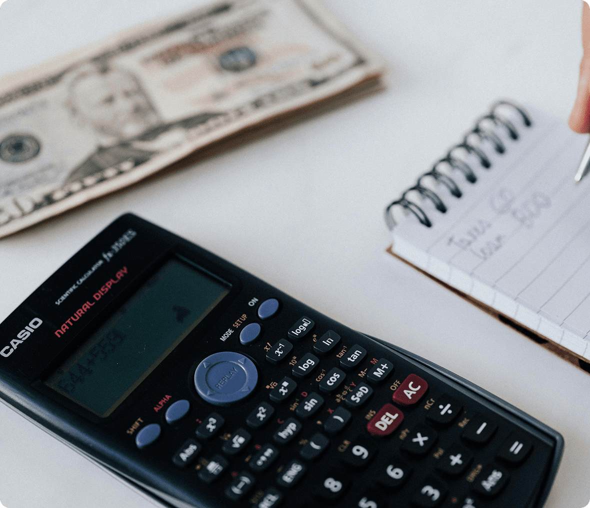 Calculator with notebook and cash